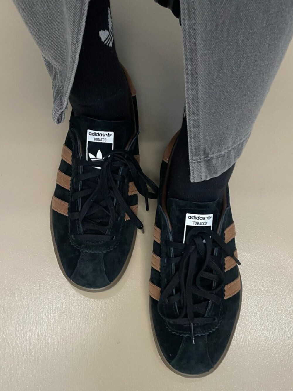 グレー系のデニムスカート、ホワイト系のトップス、ブラック系のシューズを着用したレディースの秋コーディネートの2枚目の写真