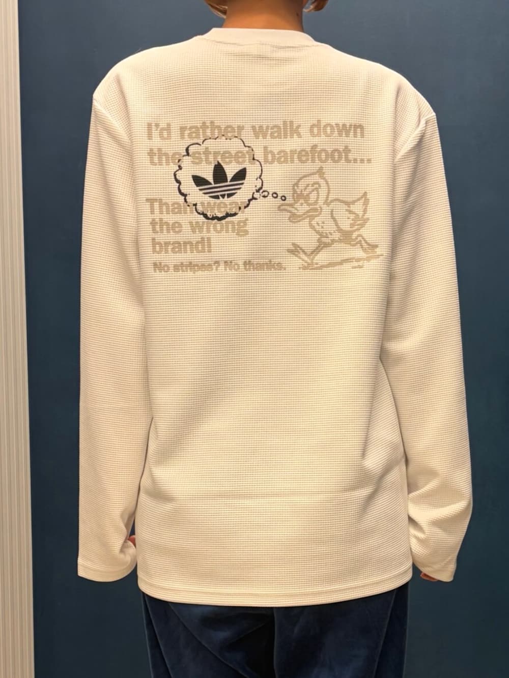 ホワイト系のTシャツ/カットソー、ベージュ系のスニーカー、ブラウン系のショルダーバッグを着用したレディースの冬コーディネートの2枚目の写真