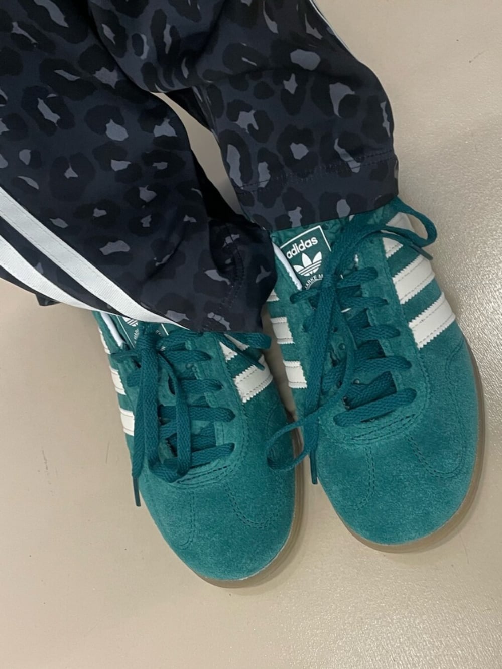 グリーン系のスニーカー、ブラック系のデニムジャケット、グレー系のその他パンツを着用したレディースの冬コーディネートの2枚目の写真