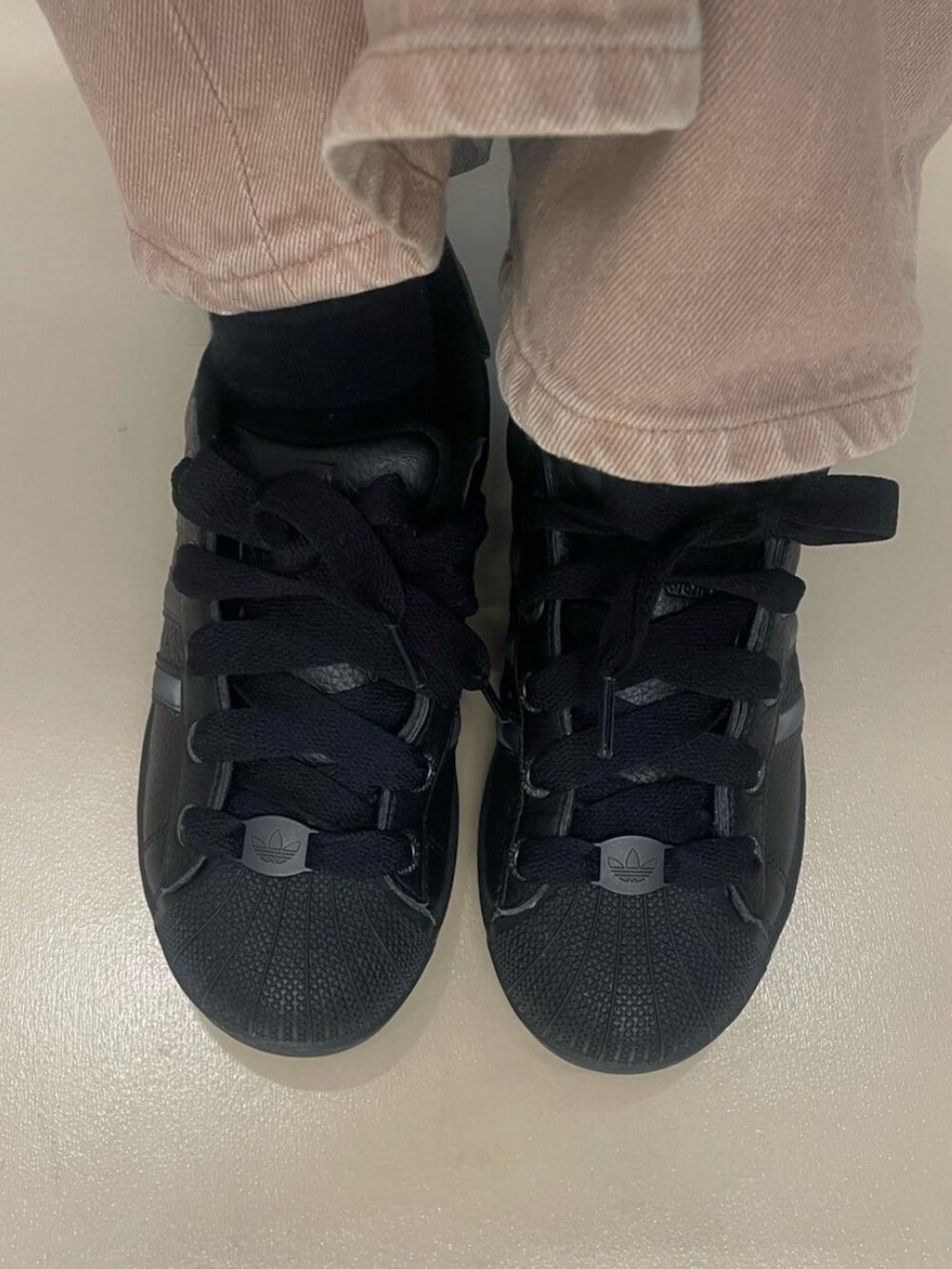 ブラック系のスニーカー、ブラック系のダウンジャケット/コート、ブラック系のニットキャップ/ビーニーを着用したレディースの秋コーディネートの2枚目の写真