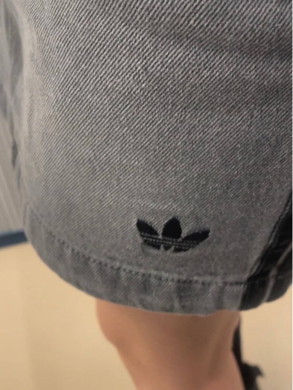 ブラック系のスニーカー、グレー系のデニムスカート、ブラック系のTシャツ/カットソーを着用したレディースの夏コーディネートの3枚目の写真