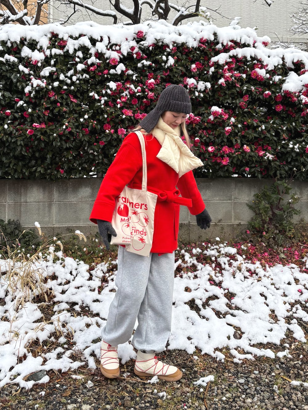 ベージュ系のトートバッグ、ホワイト系のブーツ、グレー系のスウェットパンツを着用したレディースの冬コーディネートの2枚目の写真