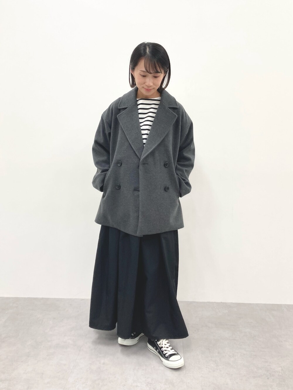 グレー系のダッフルコート、ブルー系のTシャツ/カットソーを着用したレディースの秋コーディネートの2枚目の写真