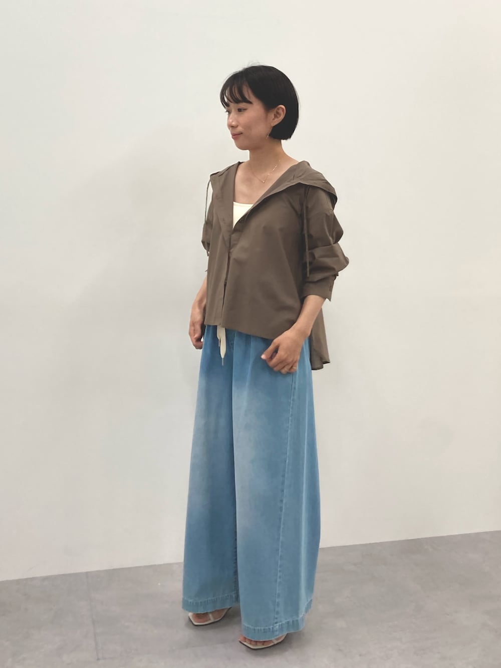 ブラウン系のシャツ/ブラウス、ブルー系のパンツを着用したレディースの春コーディネートの2枚目の写真