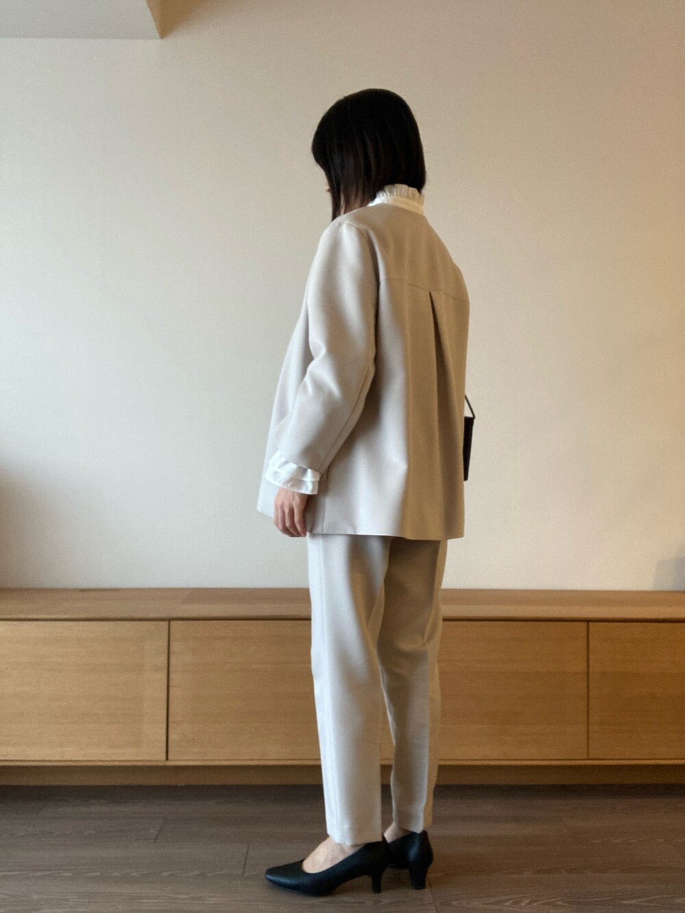 グレー系のスーツセットを着用したレディースの冬コーディネートの3枚目の写真