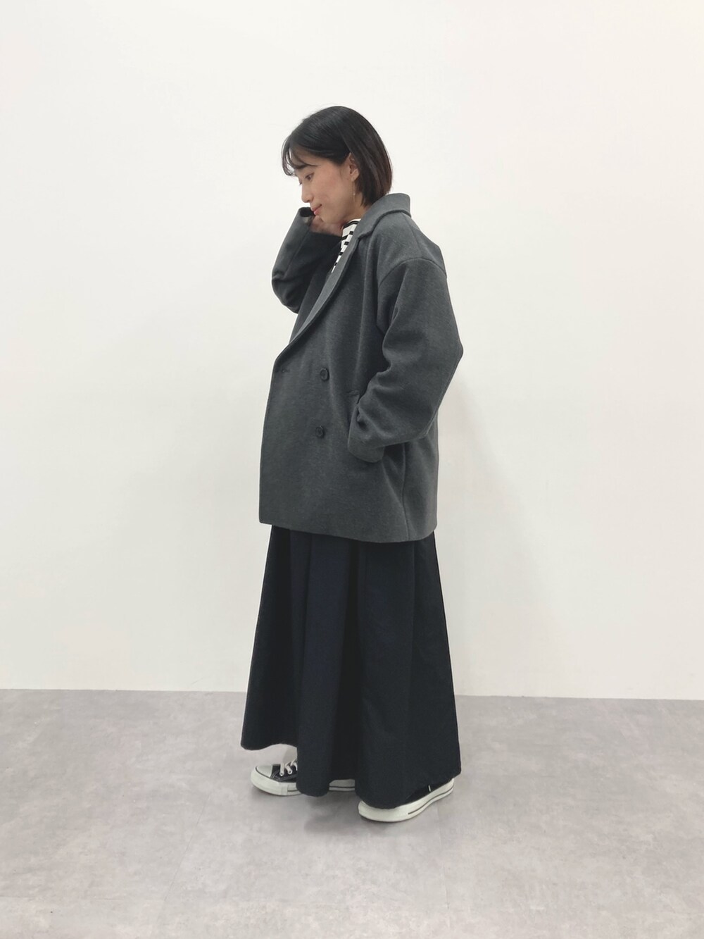 グレー系のダッフルコート、ブルー系のTシャツ/カットソーを着用したレディースの秋コーディネートの3枚目の写真