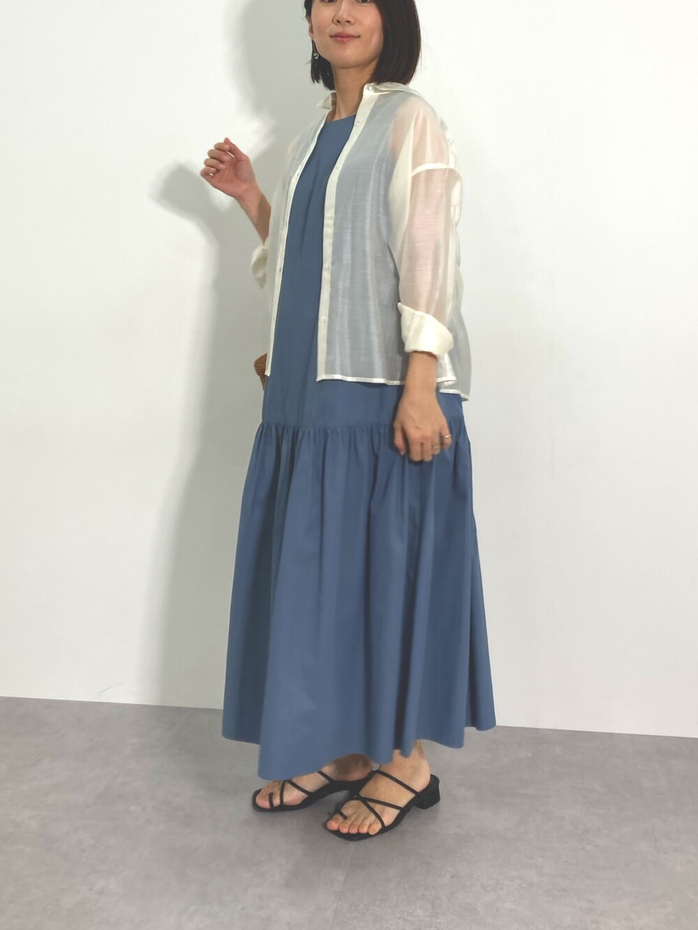 ブルー系のワンピース、ホワイト系のシャツ/ブラウスを着用したレディースの夏コーディネートの2枚目の写真