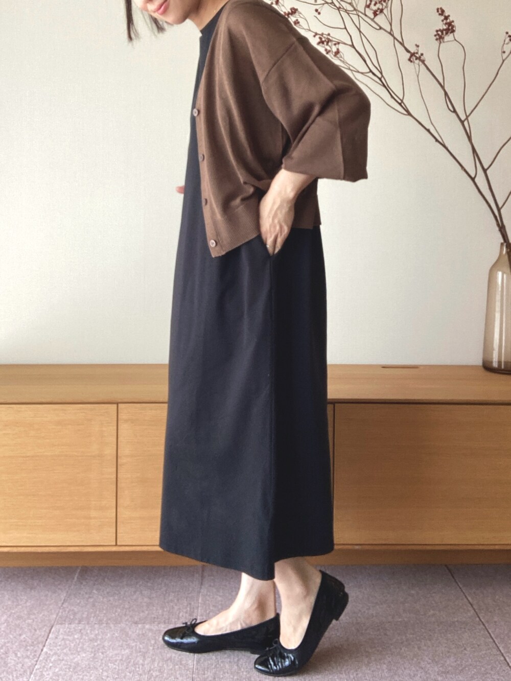 ブラック系のワンピース、ブラウン系のカーディガン/ボレロを着用したレディースの夏コーディネートの2枚目の写真