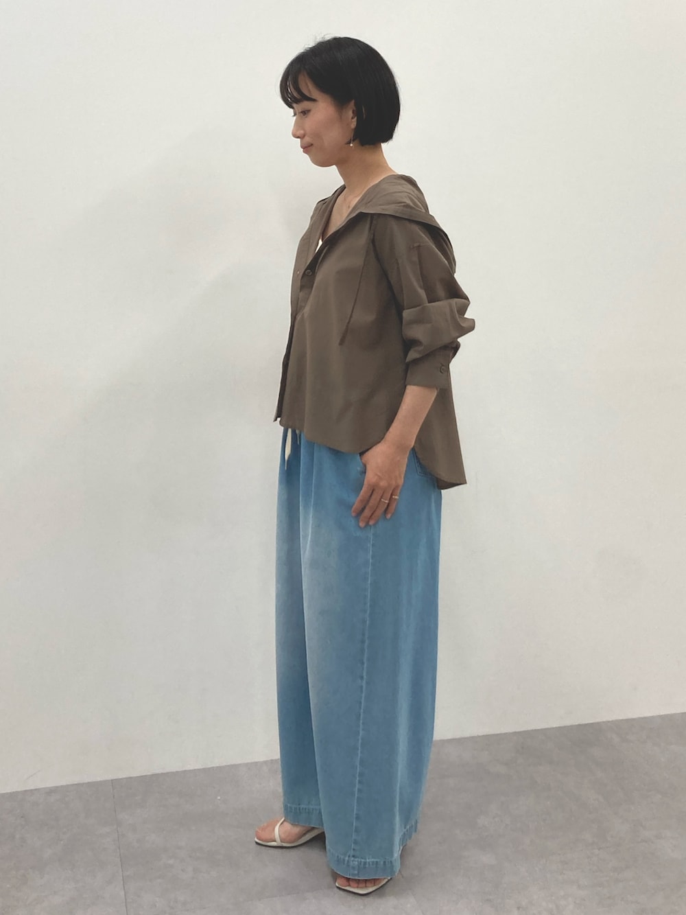 ブラウン系のシャツ/ブラウス、ブルー系のパンツを着用したレディースの春コーディネートの3枚目の写真