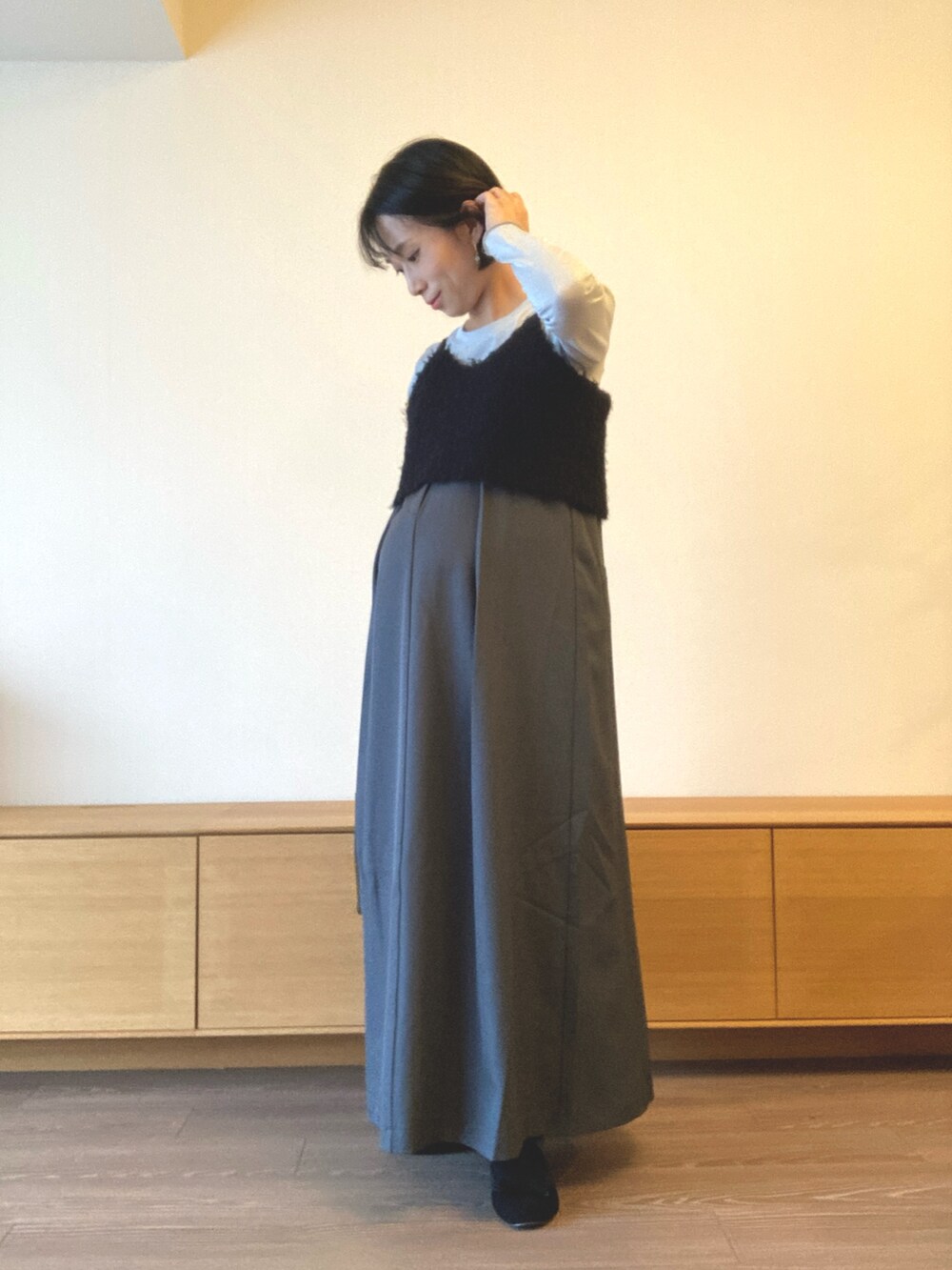 ブラック系のベストを着用したレディースの秋コーディネートの2枚目の写真