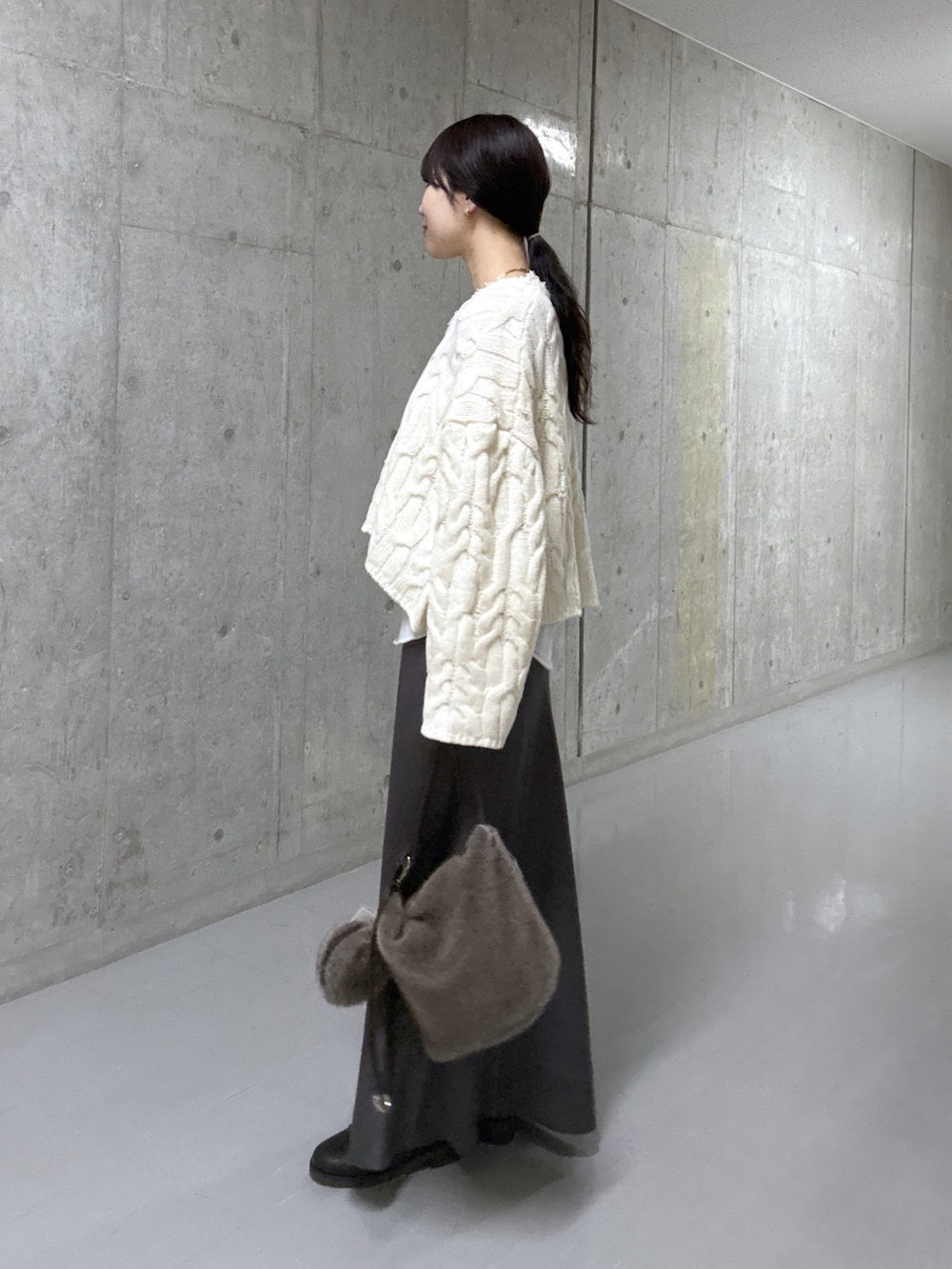 ホワイト系のTシャツ/カットソー、ホワイト系のニット/セーター、ブラウン系のスカートを着用したレディースの冬コーディネートの2枚目の写真