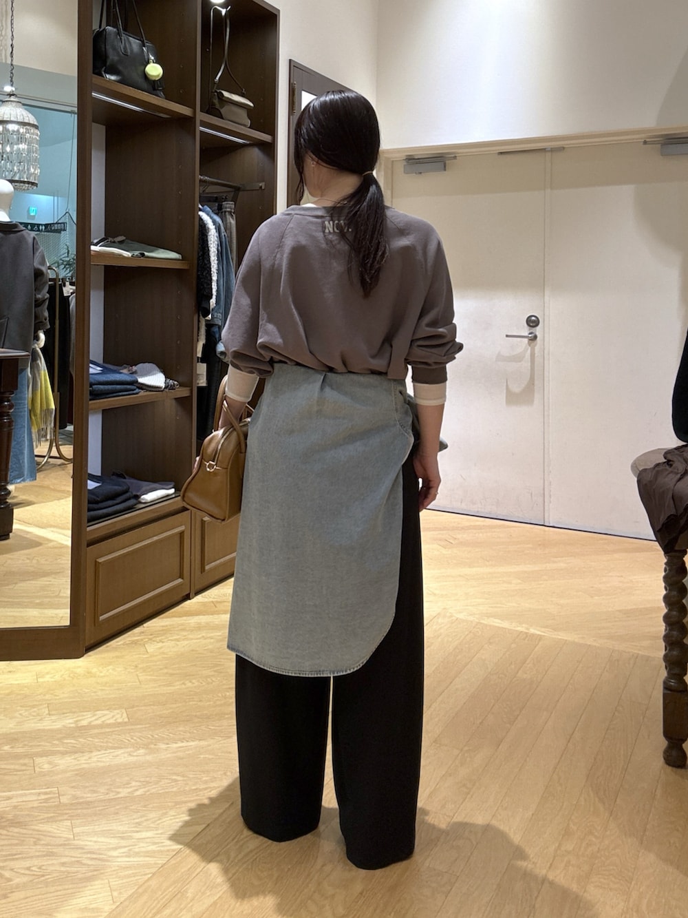 ホワイト系のTシャツ/カットソー、ブラック系のスラックス、ブルー系のシャツ/ブラウスを着用したレディースの秋コーディネートの3枚目の写真