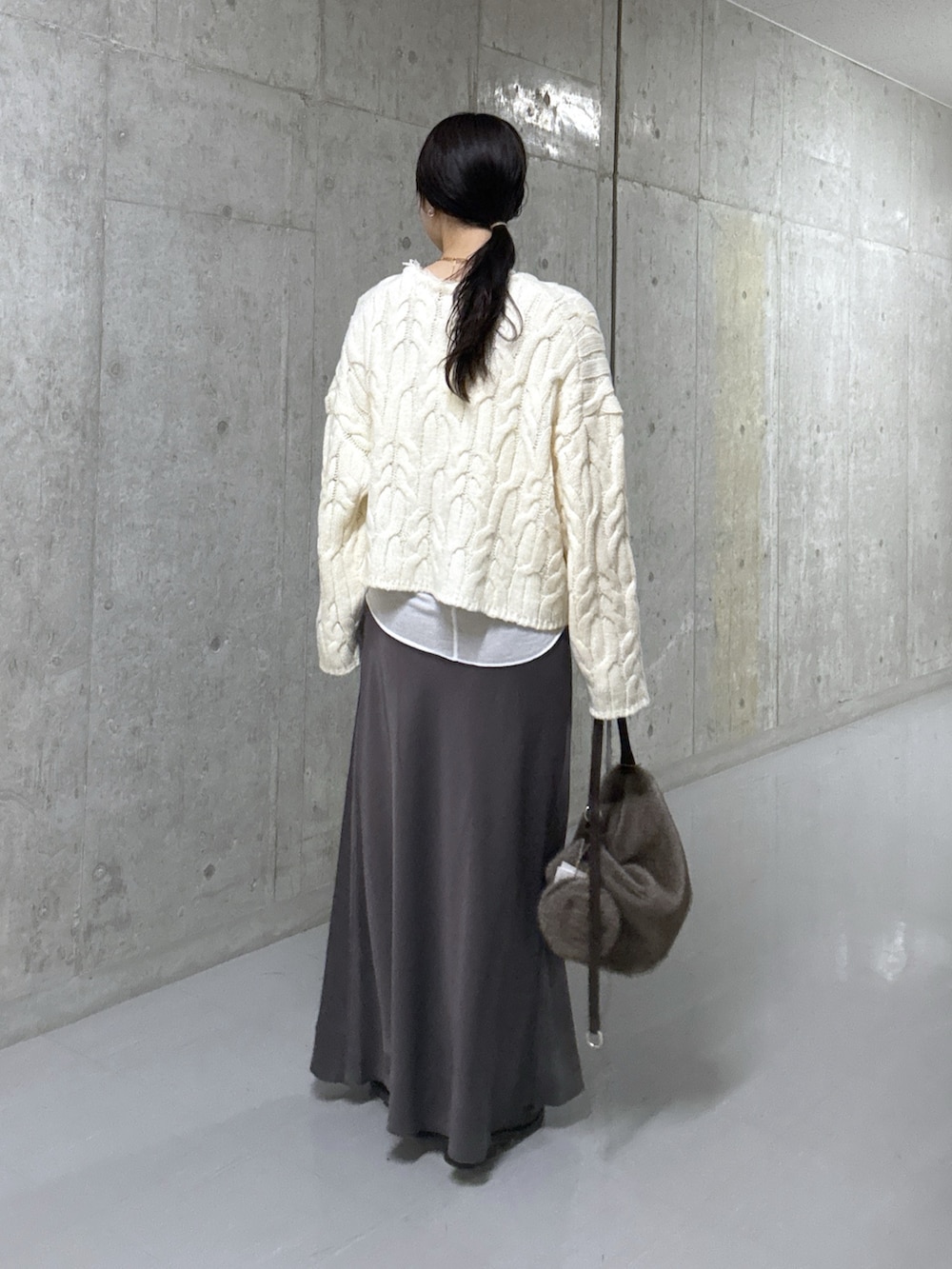 ホワイト系のTシャツ/カットソー、ホワイト系のニット/セーター、ブラウン系のスカートを着用したレディースの冬コーディネートの3枚目の写真