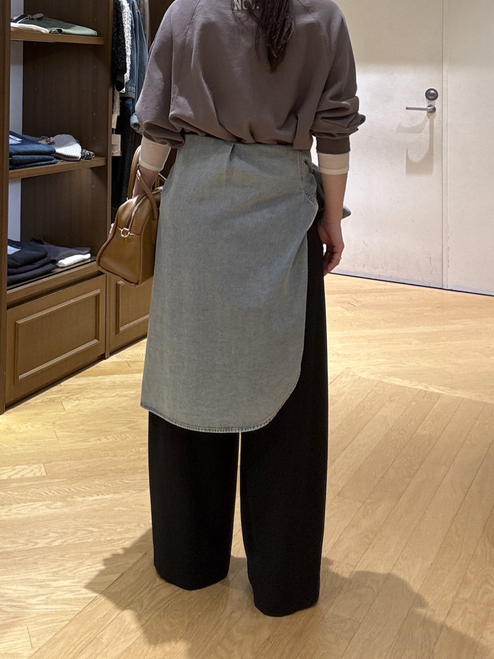 ホワイト系のTシャツ/カットソー、ブラック系のスラックス、ブルー系のシャツ/ブラウスを着用したレディースの秋コーディネートの9枚目の写真