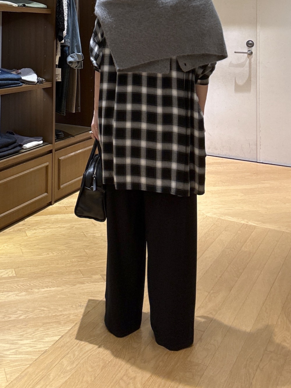 ホワイト系のTシャツ/カットソー、ブラック系のシャツ/ブラウス、ブラック系のスラックスを着用したレディースの秋コーディネートの9枚目の写真