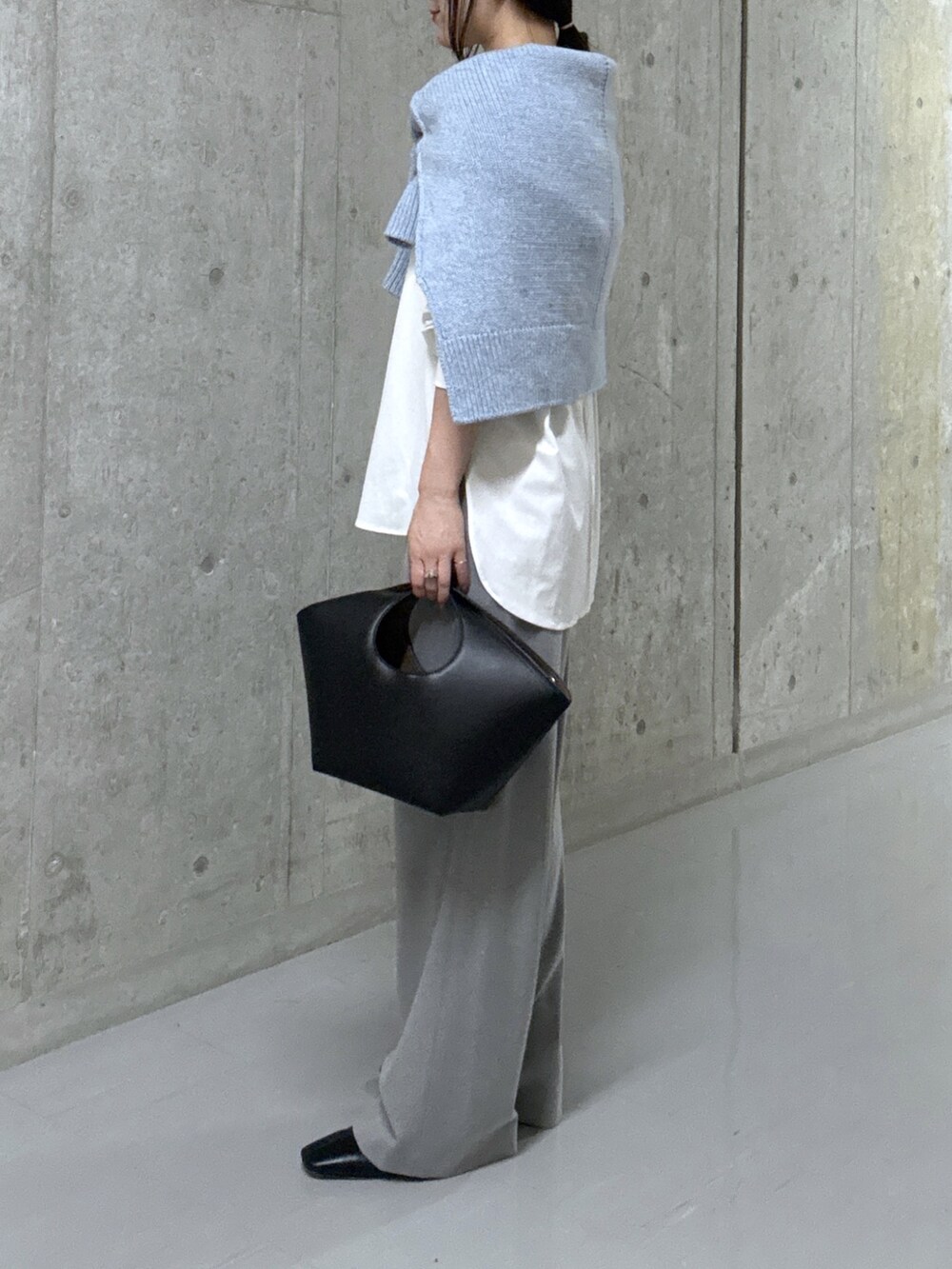 ブルー系のニット/セーター、ホワイト系のTシャツ/カットソー、ブラック系のハンドバッグを着用したレディースの秋コーディネートの8枚目の写真