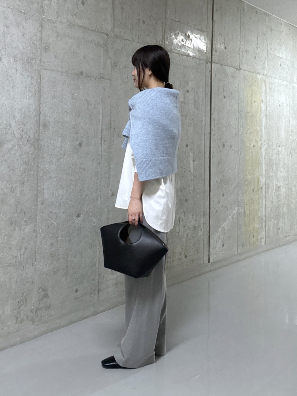 ブルー系のニット/セーター、ホワイト系のTシャツ/カットソー、ブラック系のハンドバッグを着用したレディースの秋コーディネートの2枚目の写真
