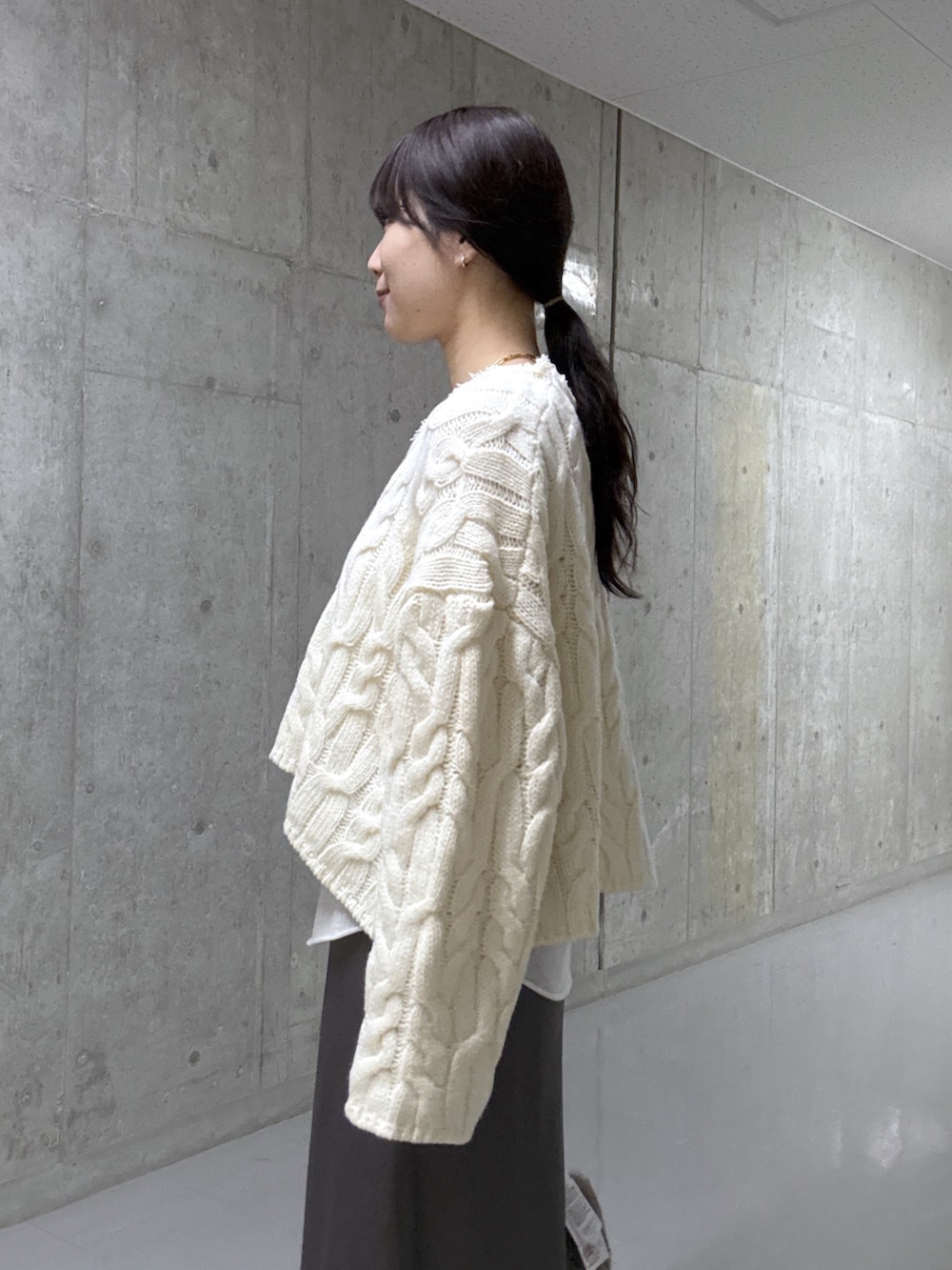 ホワイト系のTシャツ/カットソー、ホワイト系のニット/セーター、ブラウン系のスカートを着用したレディースの冬コーディネートの5枚目の写真