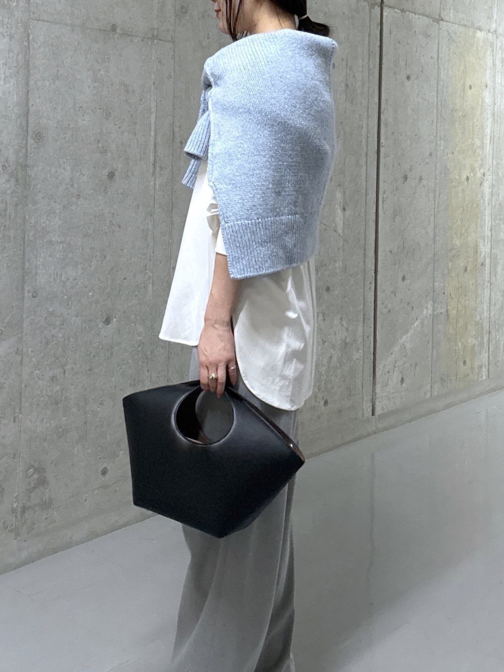 ブルー系のニット/セーター、ホワイト系のTシャツ/カットソー、ブラック系のハンドバッグを着用したレディースの秋コーディネートの5枚目の写真