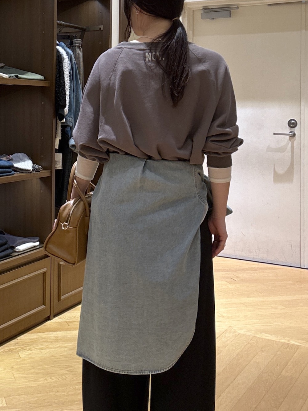 ホワイト系のTシャツ/カットソー、ブラック系のスラックス、ブルー系のシャツ/ブラウスを着用したレディースの秋コーディネートの6枚目の写真