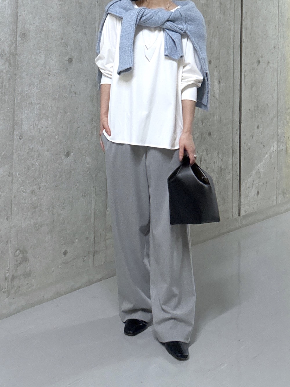 ブルー系のニット/セーター、ホワイト系のTシャツ/カットソー、ブラック系のハンドバッグを着用したレディースの秋コーディネートの7枚目の写真