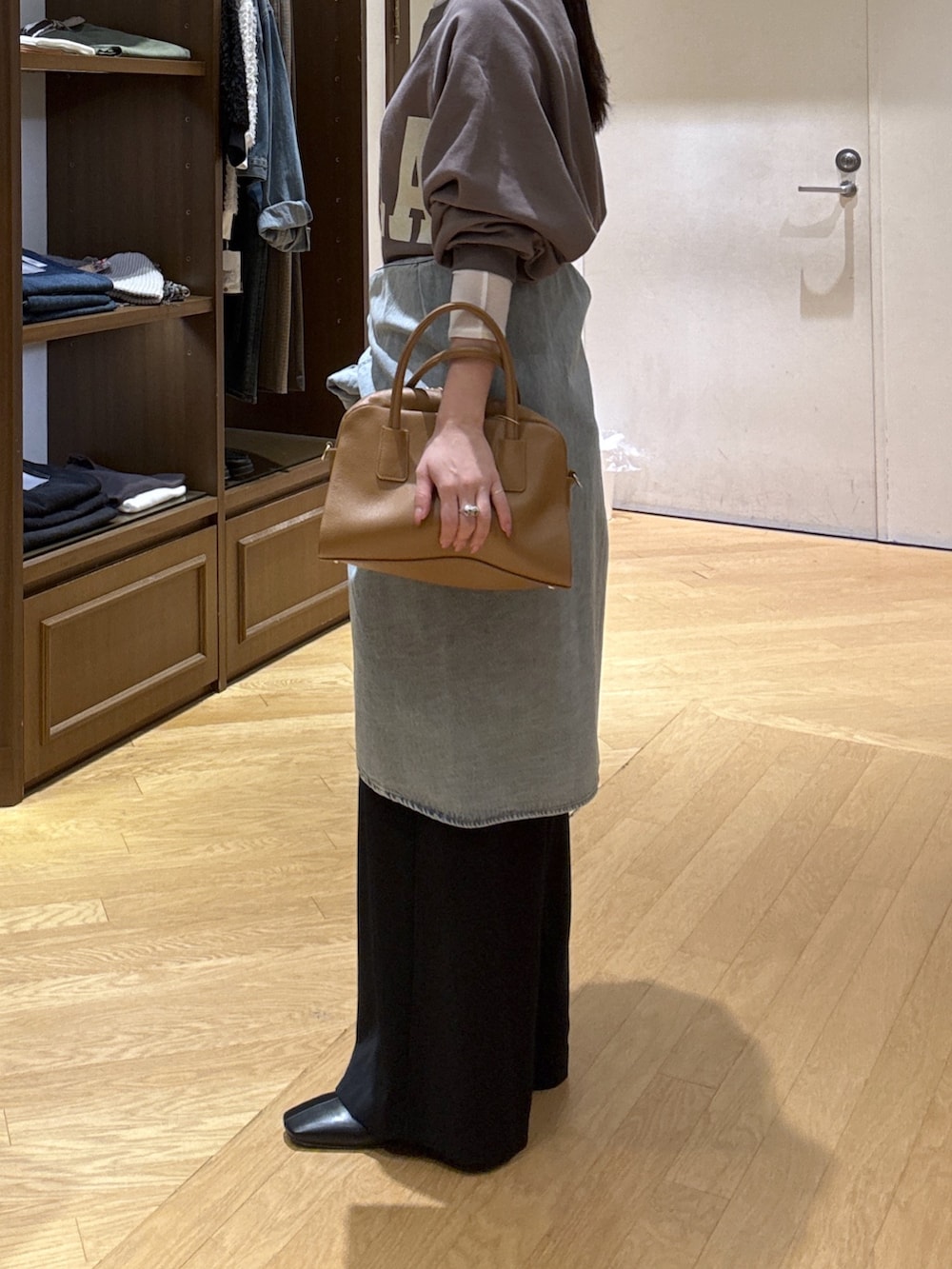 ホワイト系のTシャツ/カットソー、ブラック系のスラックス、ブルー系のシャツ/ブラウスを着用したレディースの秋コーディネートの8枚目の写真