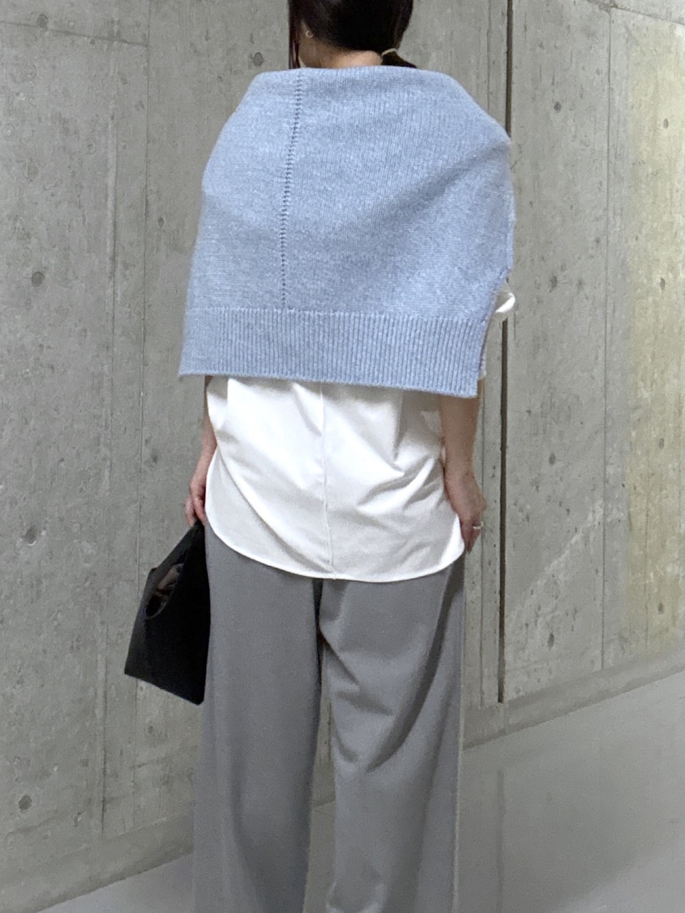 ブルー系のニット/セーター、ホワイト系のTシャツ/カットソー、ブラック系のハンドバッグを着用したレディースの秋コーディネートの6枚目の写真