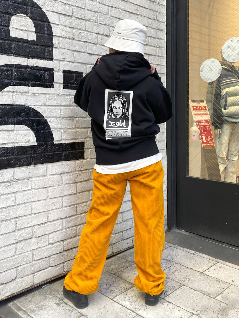 イエロー系のその他パンツ、ブラック系のパーカー、ホワイト系のハットを着用したレディースの冬コーディネートの2枚目の写真