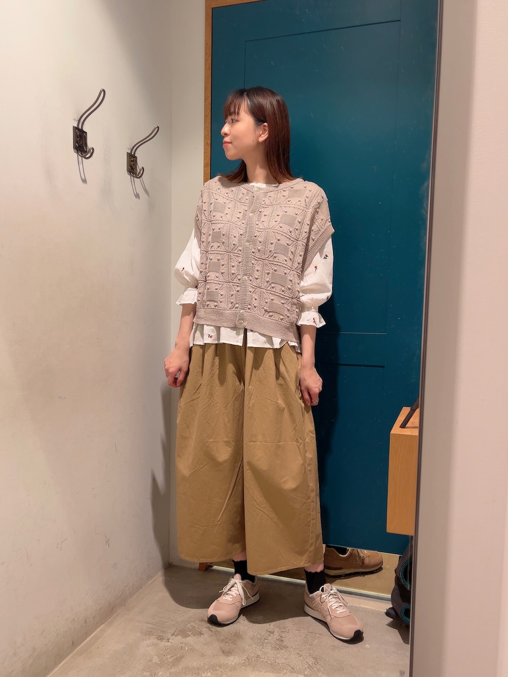 ベージュ系のベスト、ベージュ系のその他パンツ、ホワイト系のシャツ/ブラウスを着用したレディースの夏コーディネートの2枚目の写真