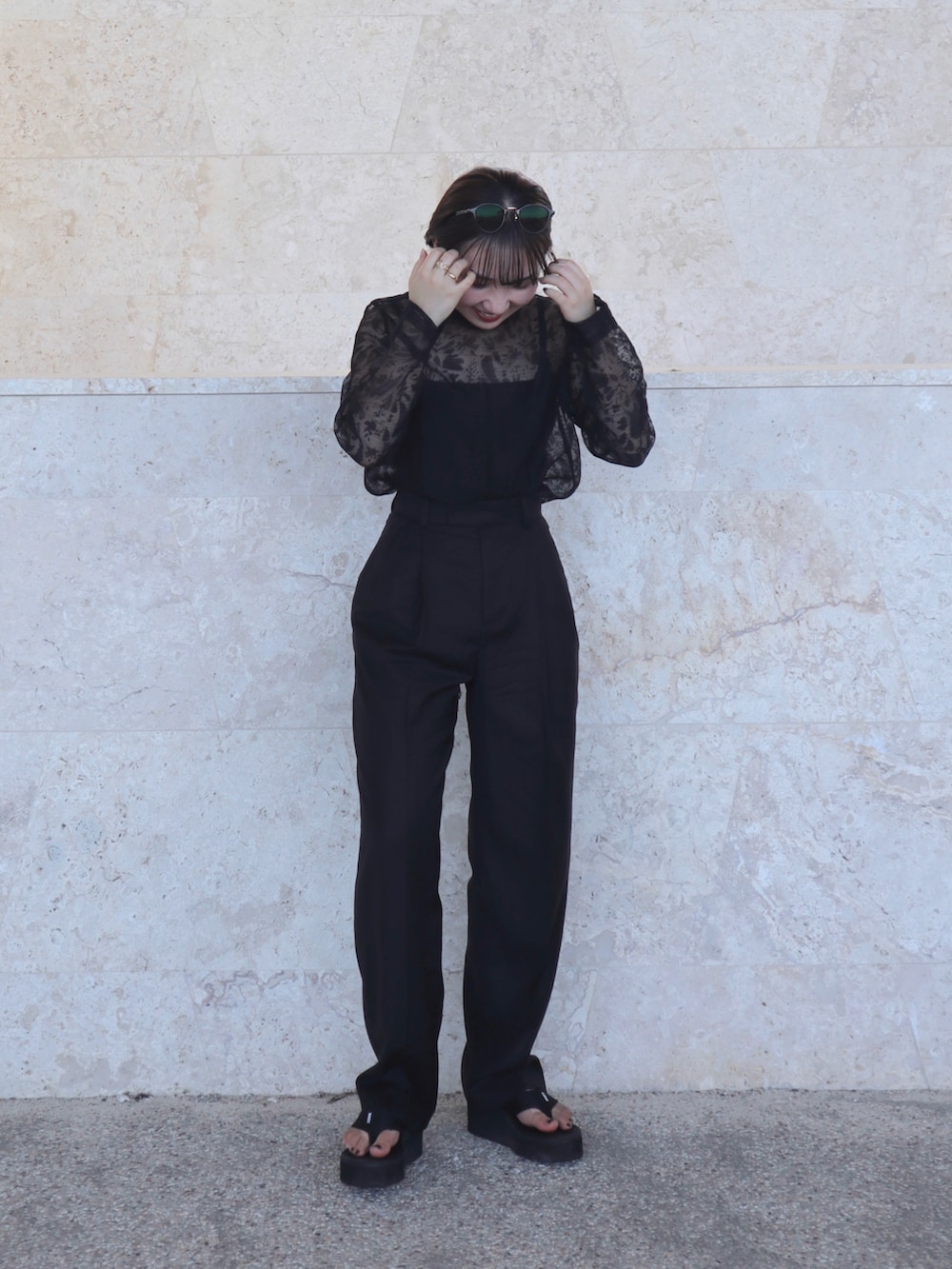 ブラック系のシャツ/ブラウス、ブラック系のパンツ、ブラック系のサンダルを着用したレディースの秋コーディネートの2枚目の写真