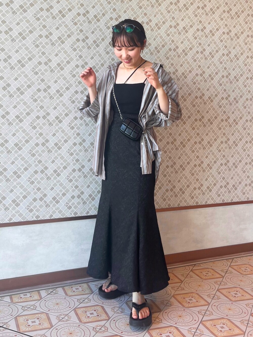 ブラック系のスカート、ブラック系のキャミソール、ブラック系のショルダーバッグを着用したレディースの夏コーディネートの3枚目の写真