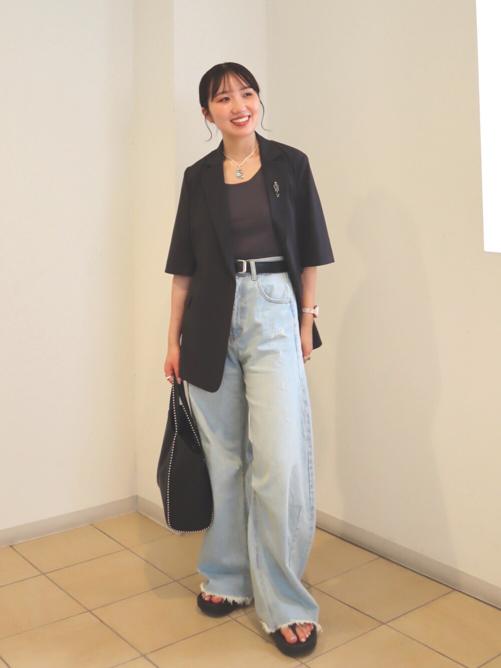 グレー系のタンクトップ、ブルー系のデニムパンツ、グレー系のその他アウターを着用したレディースの夏コーディネートの2枚目の写真