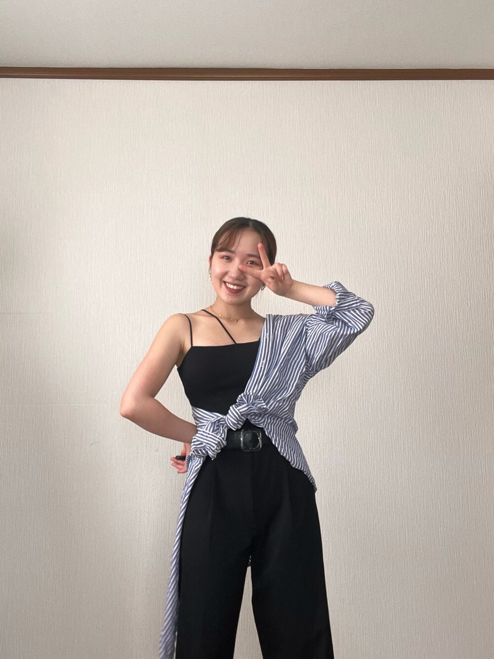 ブルー系のシャツ/ブラウス、ブラック系のデニムパンツ、ブラック系のサンダルを着用したレディースの秋コーディネートの5枚目の写真
