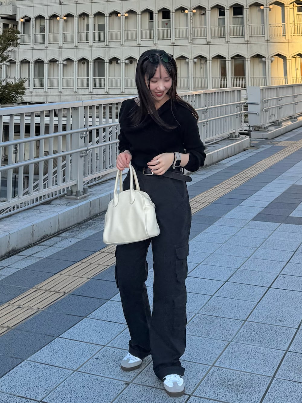 ブラック系のニット/セーター、ブラック系のカーゴパンツ、ホワイト系のボストンバッグを着用したレディースの秋コーディネートの3枚目の写真