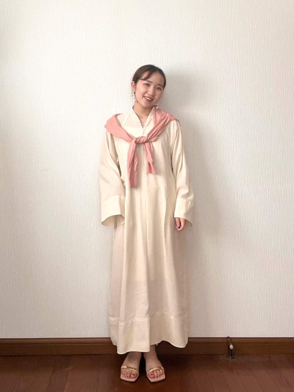 ホワイト系のワンピース、ピンク系のカーディガン/ボレロ、ベージュ系のサンダルを着用したレディースの秋コーディネートの2枚目の写真