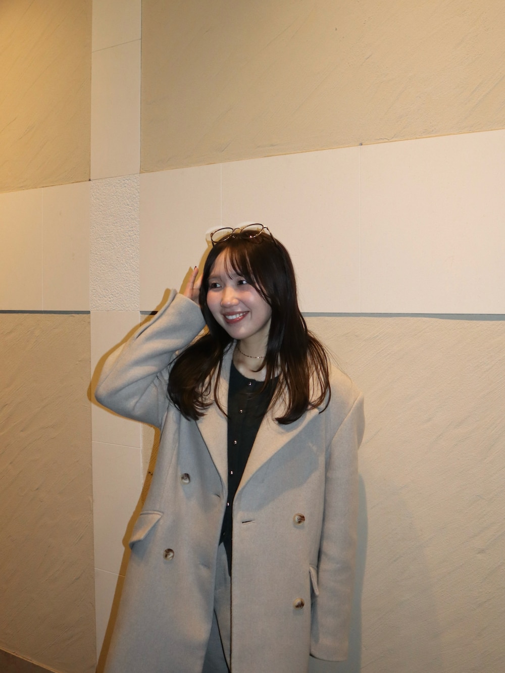 ブラック系のブーツ、ベージュ系のその他パンツ、ホワイト系のチェスターコートを着用したレディースの冬コーディネートの3枚目の写真