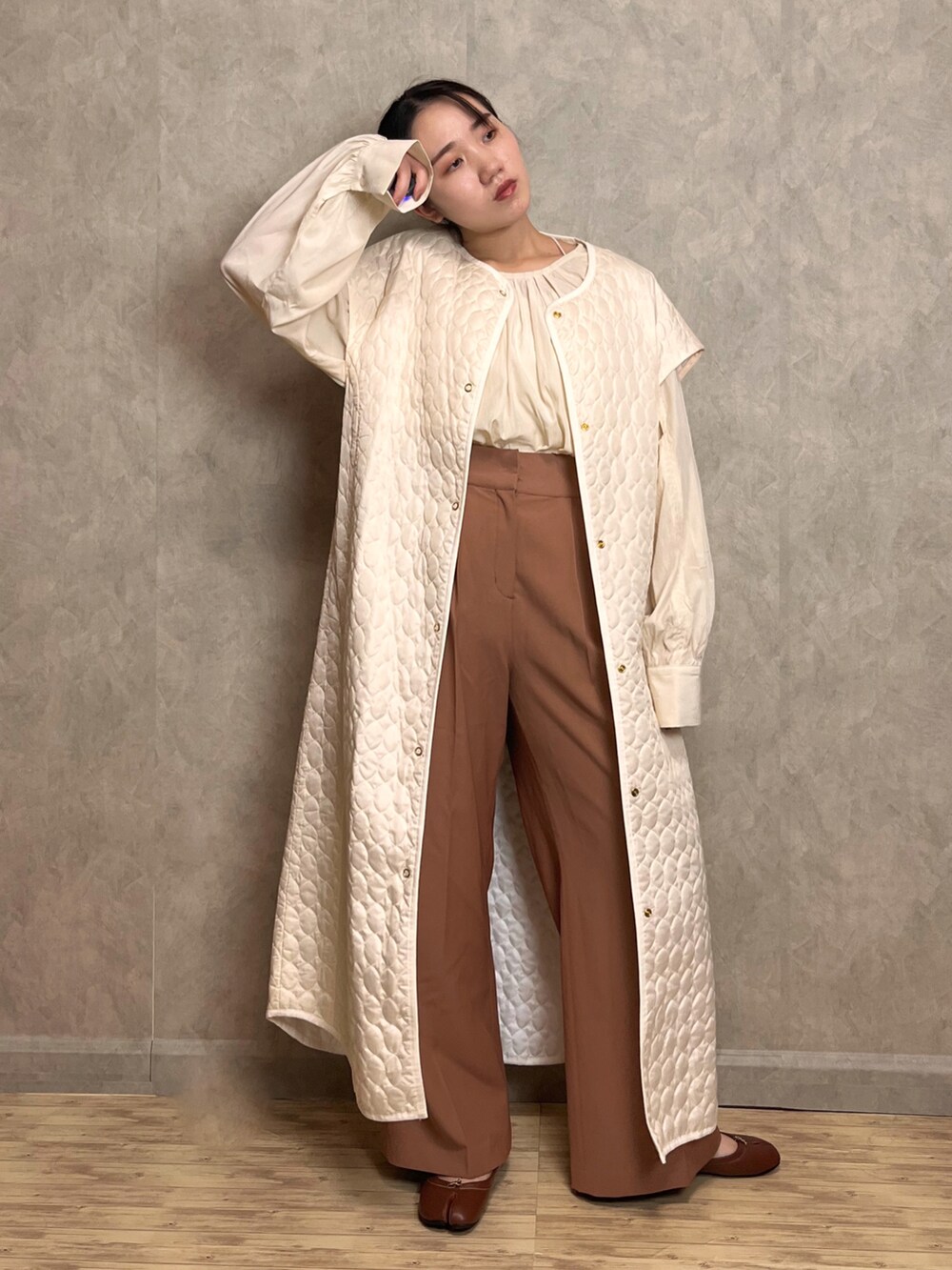 ブラウン系のスラックス、ホワイト系のシャツ/ブラウス、ホワイト系のベストを着用したレディースの秋コーディネートの3枚目の写真