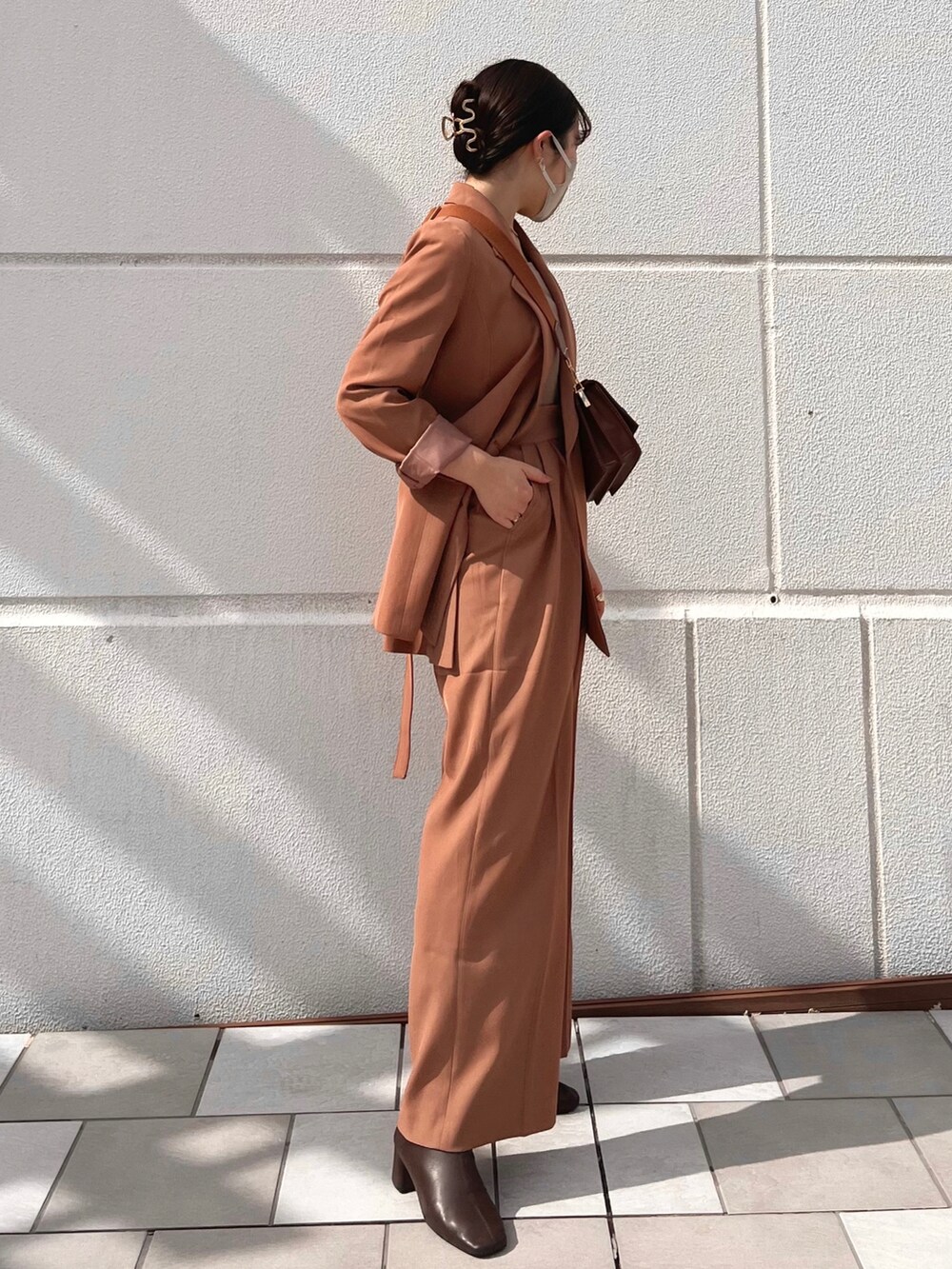 ブラウン系のテーラードジャケット、ブラウン系のブーツ、ブラック系のショルダーバッグを着用したレディースの秋コーディネートの3枚目の写真