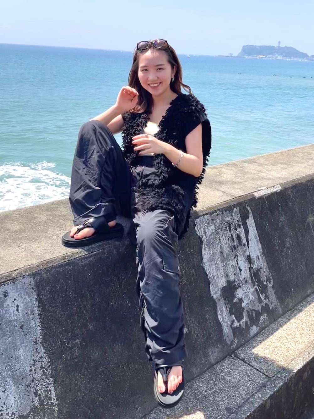 ブラック系のその他パンツ、ブラック系のベスト、イエロー系のタンクトップを着用したレディースの秋コーディネートの4枚目の写真