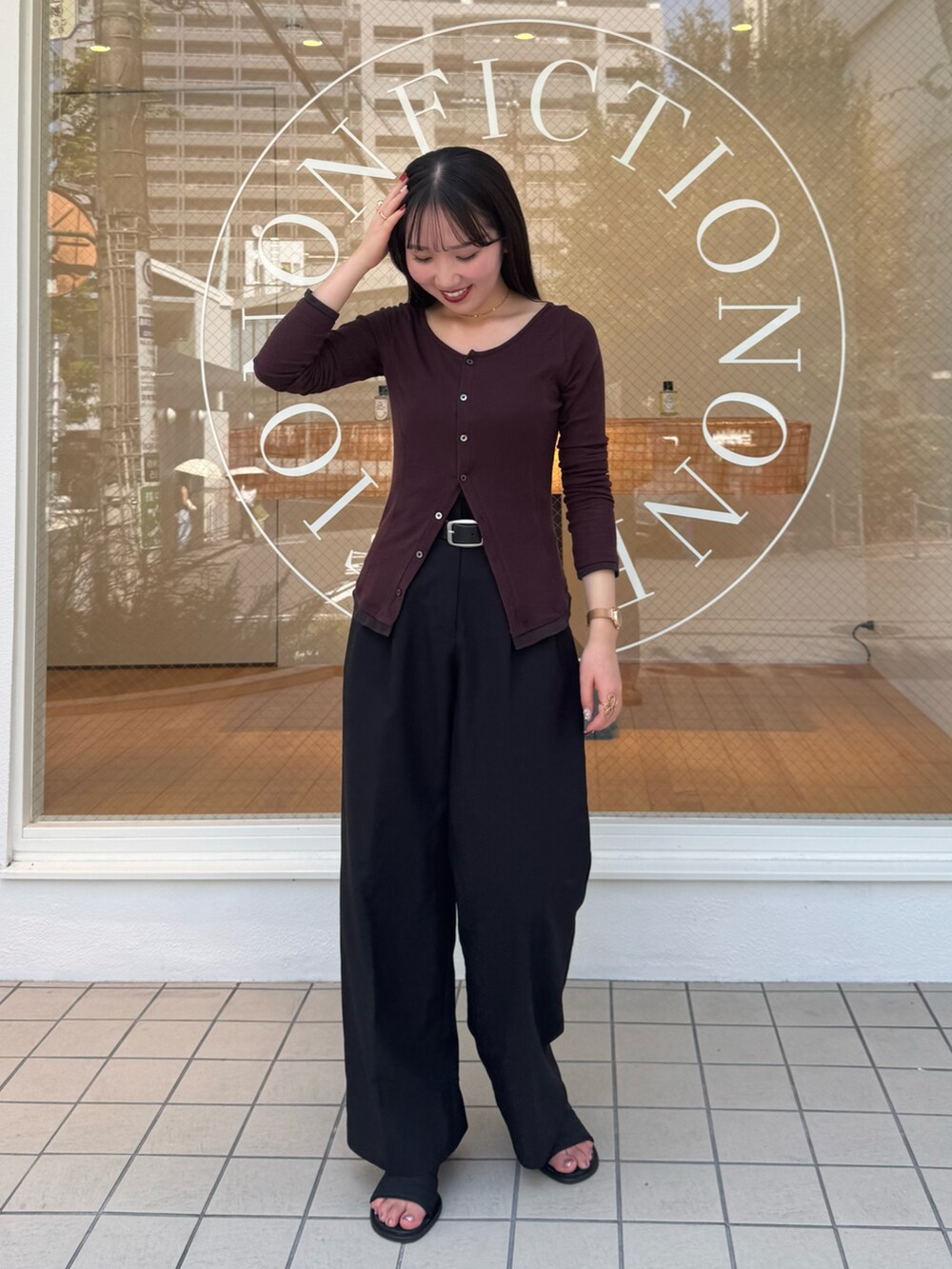 ブラック系のスラックス、レッド系のTシャツ/カットソー、ブラック系のサンダルを着用したレディースの秋コーディネートの3枚目の写真