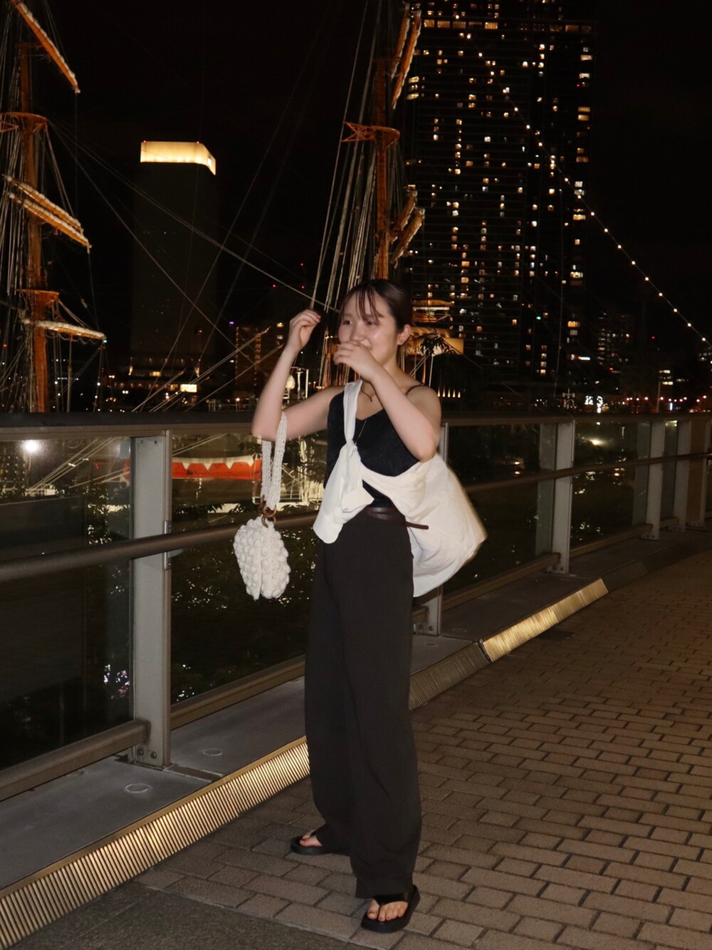 ホワイト系のシャツ/ブラウス、ブラウン系のスラックス、ブラック系のキャミソールを着用したレディースの夏コーディネートの2枚目の写真