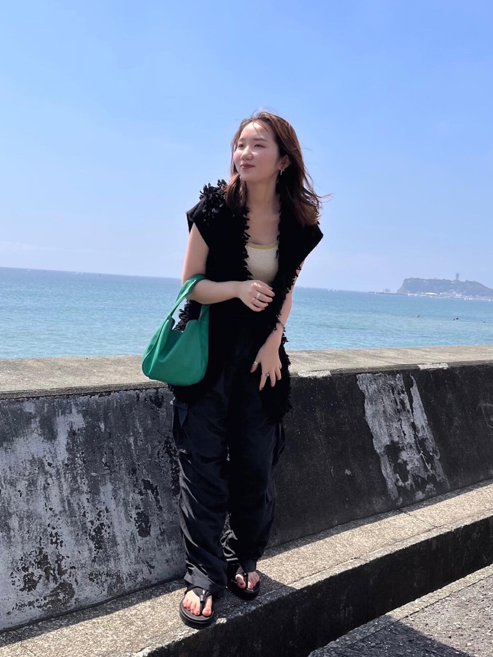 ブラック系のその他パンツ、ブラック系のベスト、イエロー系のタンクトップを着用したレディースの秋コーディネートの2枚目の写真