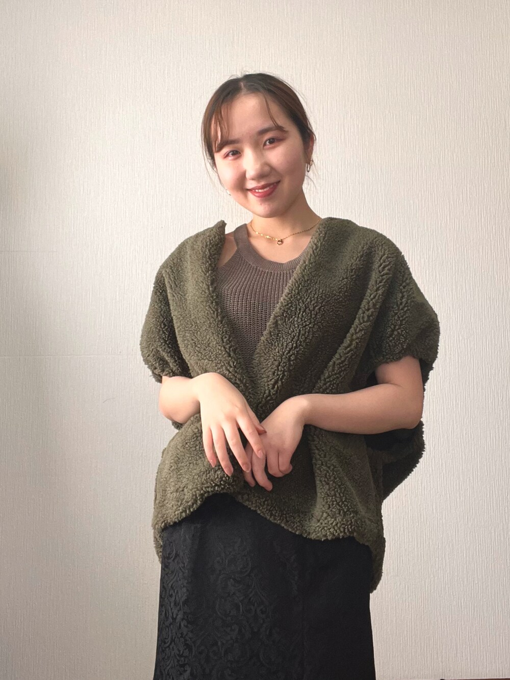 ブラック系のスカート、ブラック系のサンダル、グリーン系のタンクトップを着用したレディースの秋コーディネートの5枚目の写真