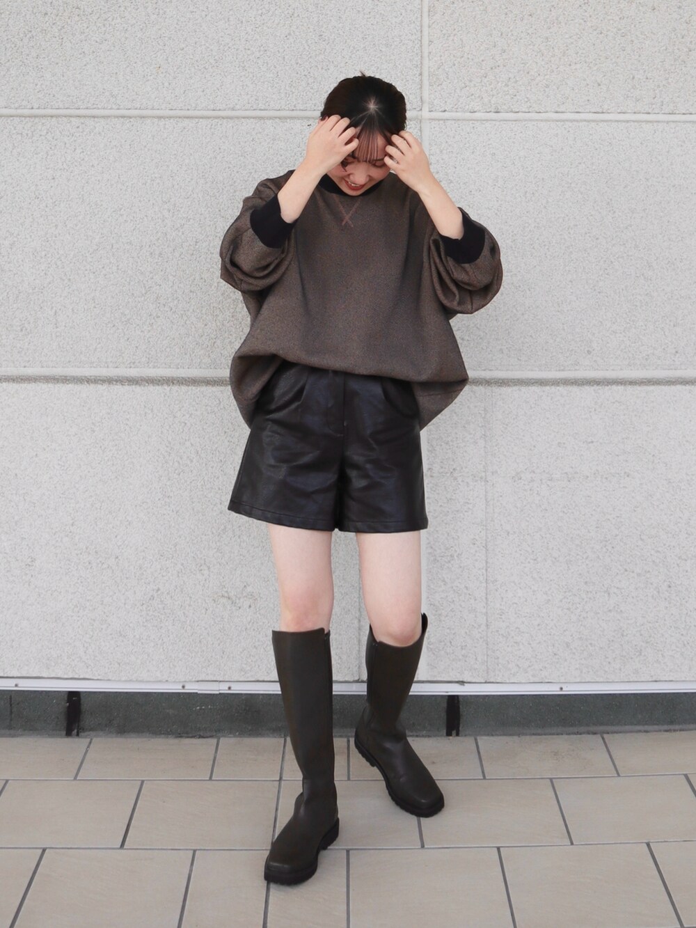 ブラック系のその他パンツ、オレンジ系のニット/セーター、グリーン系のブーツを着用したレディースの秋コーディネートの2枚目の写真