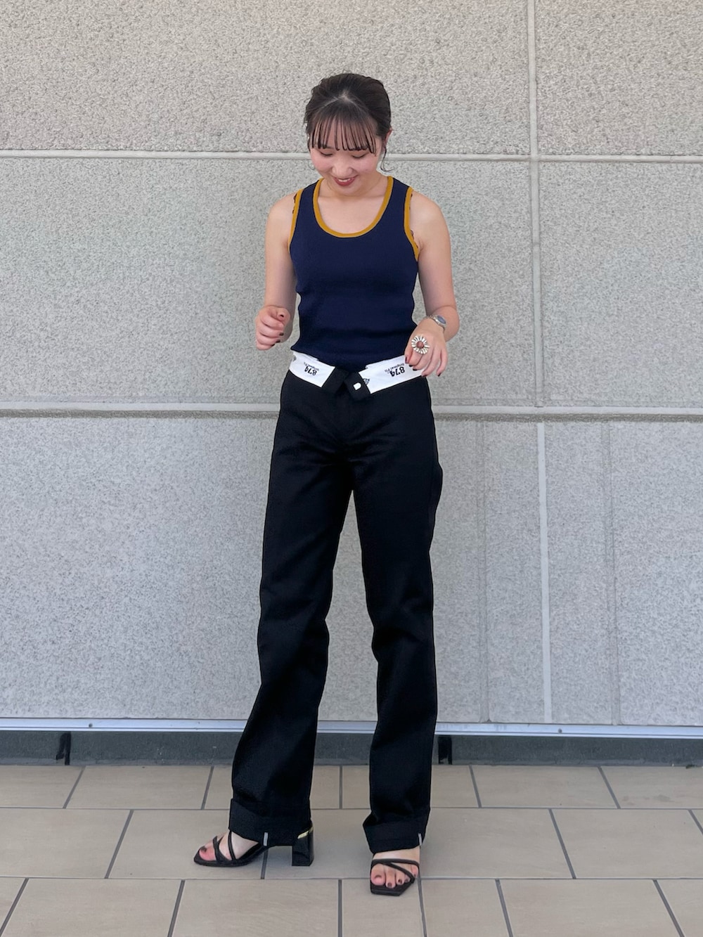 ブラック系のチノパンツ、ブルー系のタンクトップ、ブラック系のサンダルを着用したレディースの秋コーディネートの2枚目の写真