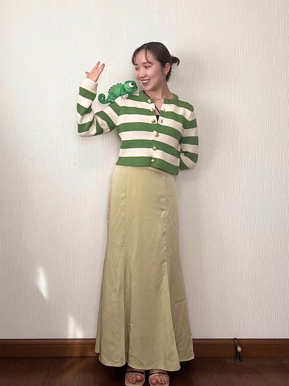 イエロー系のスカート、グリーン系のカーディガン/ボレロ、ベージュ系のサンダルを着用したレディースの秋コーディネートの3枚目の写真