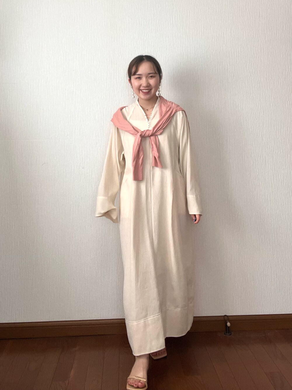 ホワイト系のワンピース、ピンク系のカーディガン/ボレロ、ベージュ系のサンダルを着用したレディースの秋コーディネートの3枚目の写真