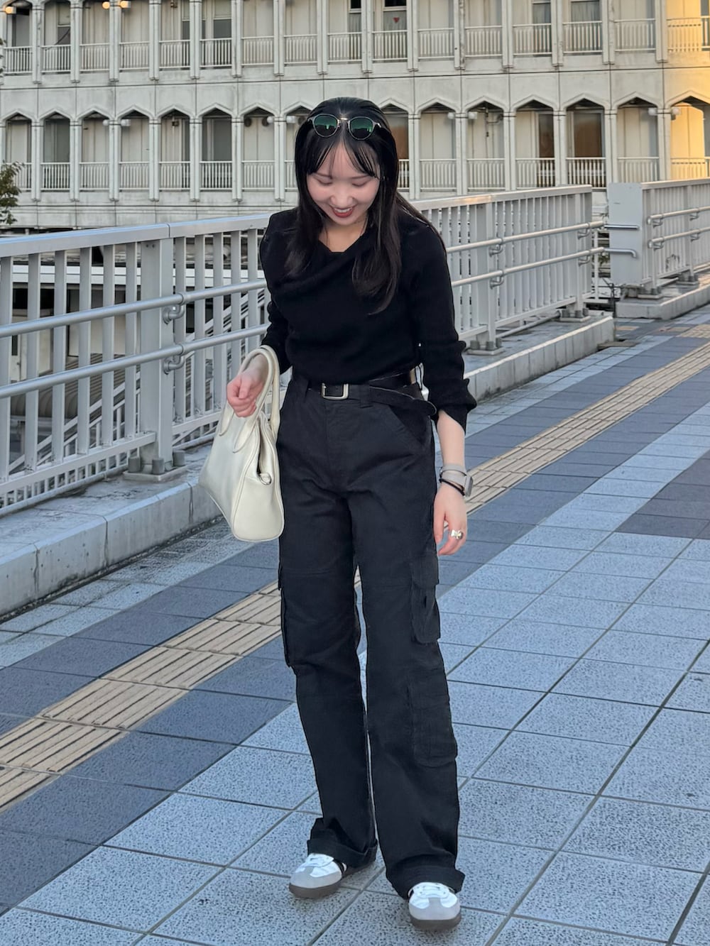 ブラック系のニット/セーター、ブラック系のカーゴパンツ、ホワイト系のボストンバッグを着用したレディースの秋コーディネートの2枚目の写真