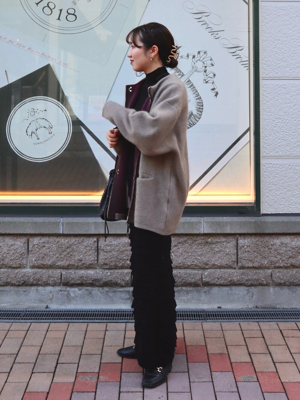 ブラック系のスカート、ブラウン系のカーディガン/ボレロ、ブラック系のその他トップスを着用したレディースの秋コーディネートの3枚目の写真