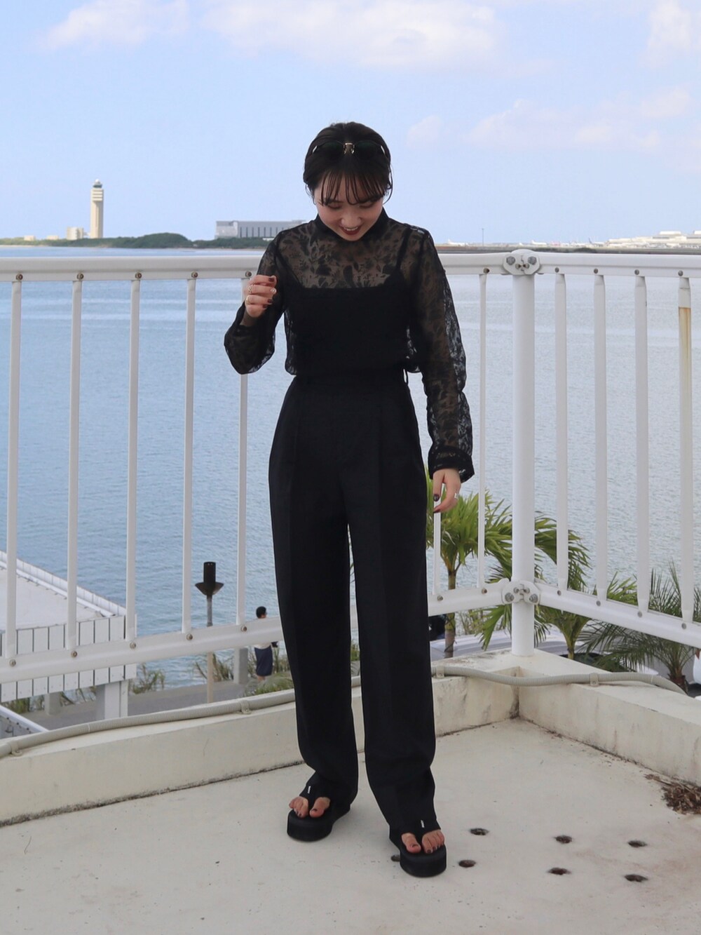 ブラック系のシャツ/ブラウス、ブラック系のパンツ、ブラック系のサンダルを着用したレディースの秋コーディネートの3枚目の写真